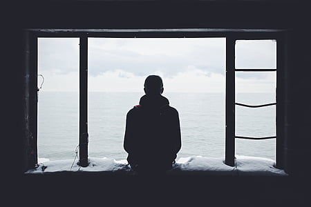 man sitting while looking at the sea thumbnail