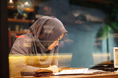 woman sitting at table reading paper thumbnail