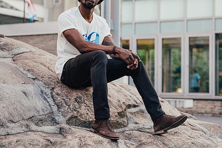 Casual Man Sits On Rock Photo thumbnail