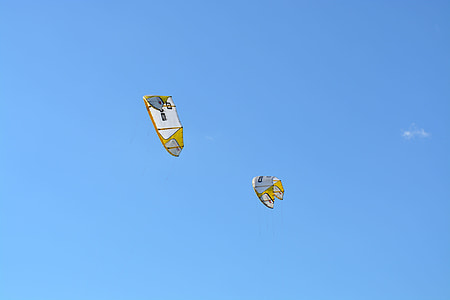 two white and yellow powered paragliding equipment flying in the sky thumbnail