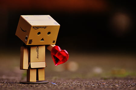 selective focus photography of brown cardboard box person holding heart thumbnail