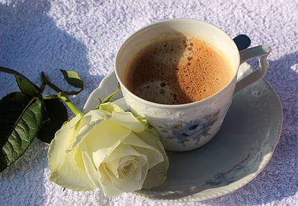 white rose beside teacup filled with coffee thumbnail