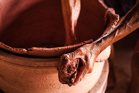 person molding clay pot thumbnail