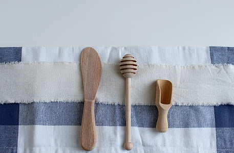 high angle photography of three wooden kitchen tools on white and blue textile thumbnail