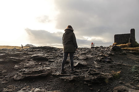 person standing on ground near black and white buildings during daytime thumbnail