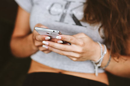 Young woman holding the white mobile phone thumbnail