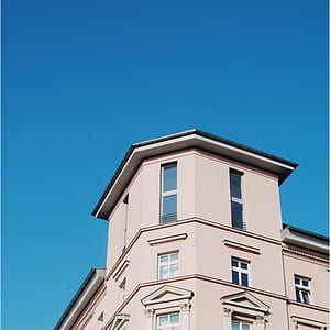 beige concrete house under blue sky during daytime thumbnail