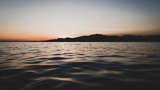 silhouette of island on body of water thumbnail