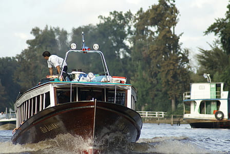 man standing on top of boat thumbnail