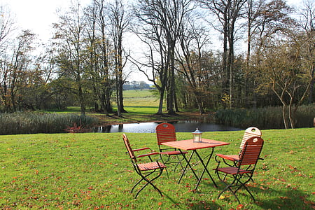 brown folding table and chairs near pond thumbnail