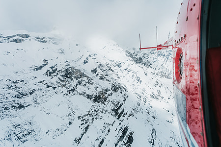 photo of mountain covered in ice from inside helicopter thumbnail