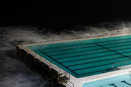 olympic size swimming pool near body of water thumbnail