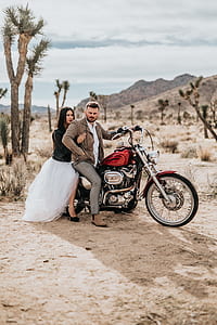 man and woman riding on red chopper motorcycle during daytime thumbnail