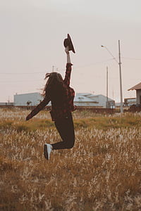 time lapse photography of woman jumping under brown grass thumbnail