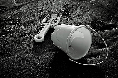 grayscale photo of bucket and shovel on sand thumbnail