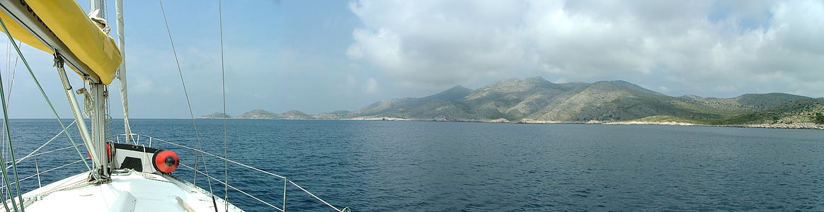 white boat on body of water under white and blue skies during day time thumbnail