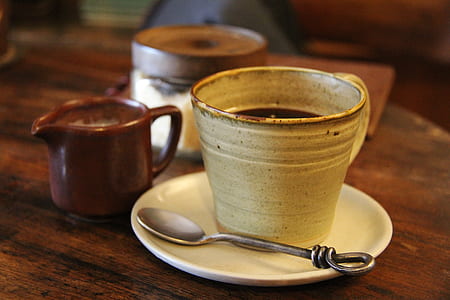 black liquid filled mug with saucer and teaspoon thumbnail
