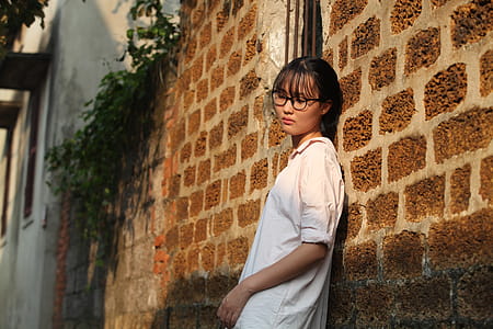 Woman Leaning on Brown Brick Wall thumbnail