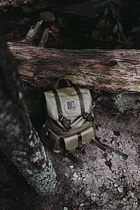 gray leather bucket backpack beside tree thumbnail
