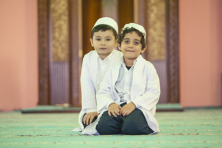 two boys kneeling on green floor thumbnail