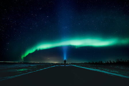 man standing under Northern lights during night time thumbnail