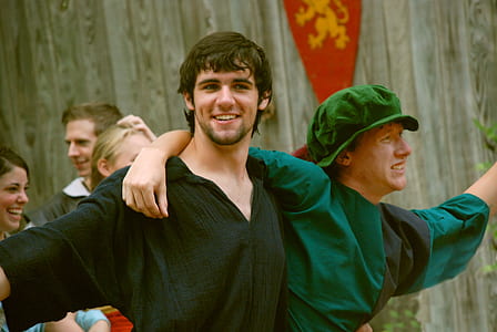 smiling man beside man wearing green suit thumbnail
