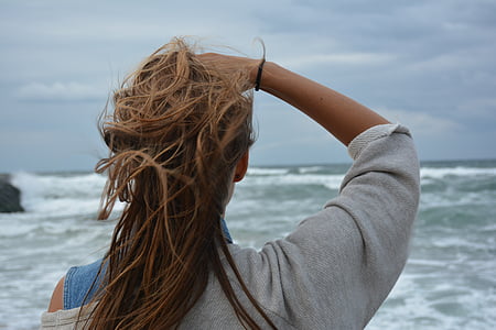 woman facing sea under nimbus clouds thumbnail