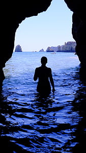 person walking out inside oncean cave at daytime thumbnail