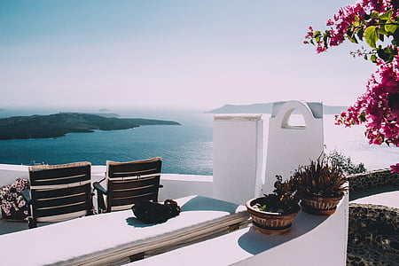 two brown plant pots near brown wooden chairs thumbnail