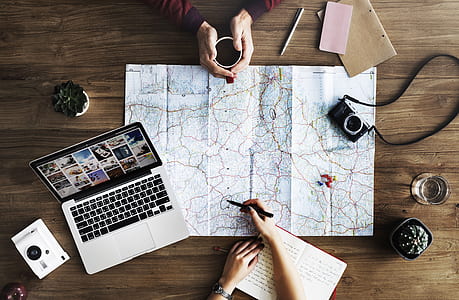 person holding black pen pointing at white and brown map thumbnail