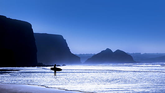 person carrying inflatable on shoreline thumbnail