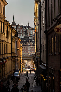 people walking in between concrete buildings thumbnail