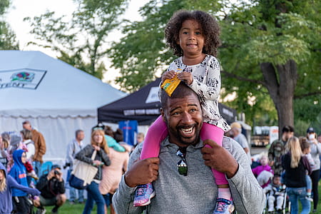 Girl Sitting on Smiling Man's Shoulder thumbnail