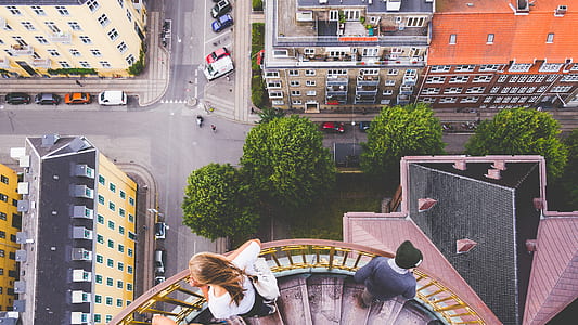 two person on stairs looking down on buildings and road thumbnail