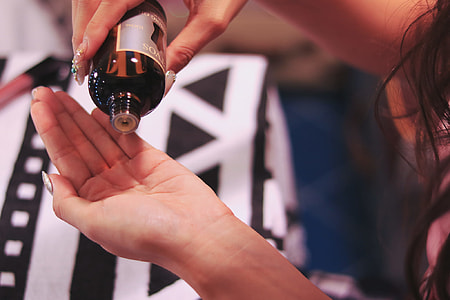 person pouring liquid from black bottle thumbnail
