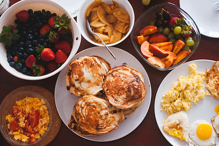 Breakfast spread on table including eggs, omelettes and fruit thumbnail