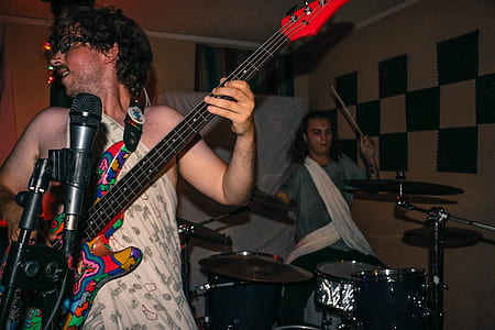 two men playing instrument inside room thumbnail