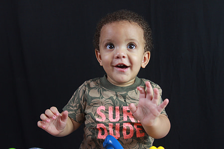 baby standing in front of black fabric covered backdrop thumbnail