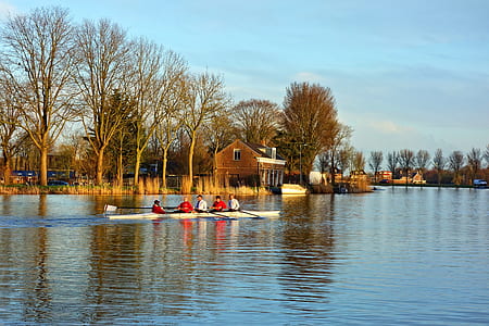 five person on boat near trees under blue sky thumbnail