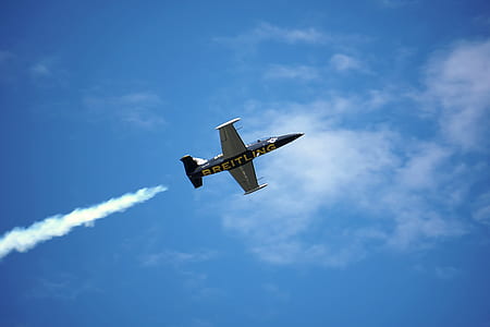gray and black Breitling plane under blue and white sky at daytime thumbnail