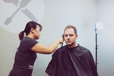 woman wearing black shirt cutting man hair thumbnail