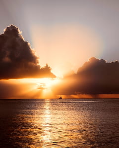 sail boat under gray and blue sky during golden hour thumbnail