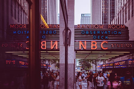 people walks under NBC signage during daytime thumbnail
