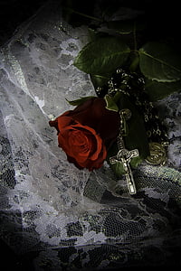 red rose beside silver-colored rosary on white lace textile thumbnail