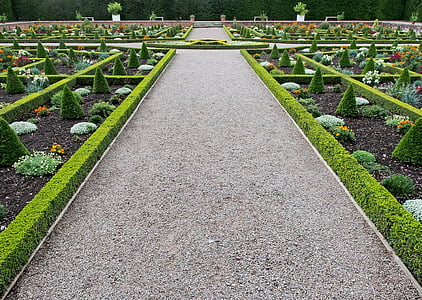gray gravel pathway surrounded by green leafed plants taken at daytime thumbnail