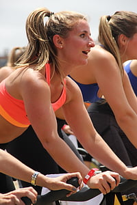 woman sitting on stationary bike while smiling thumbnail