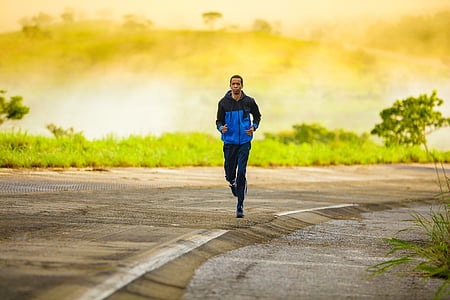 man wearing blue and black jacket and pants running on road thumbnail