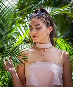 woman holding sago palm leaves during daytime thumbnail