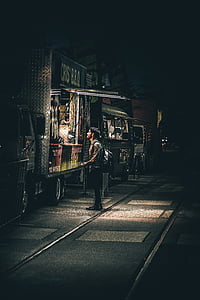 man standing in front of black food stall thumbnail