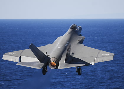 gray fighting jet near body of water thumbnail